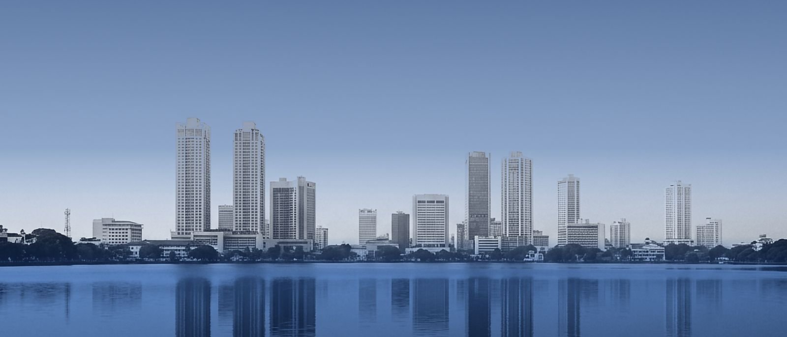 Colombo skyline across Beira Lake, reflected in still water